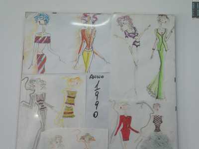 Sulle pareti bianche sono invece appesi quadri di bozzetti realizzati a matita accanto a fotografie di sfilate di moda